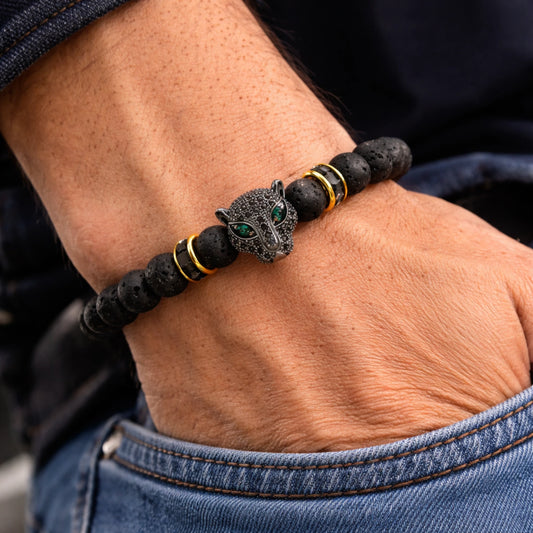 Bracelet with a panther design on a wrist, worn with blue jeans.