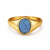 Gold ring with a blue stone on a white background
