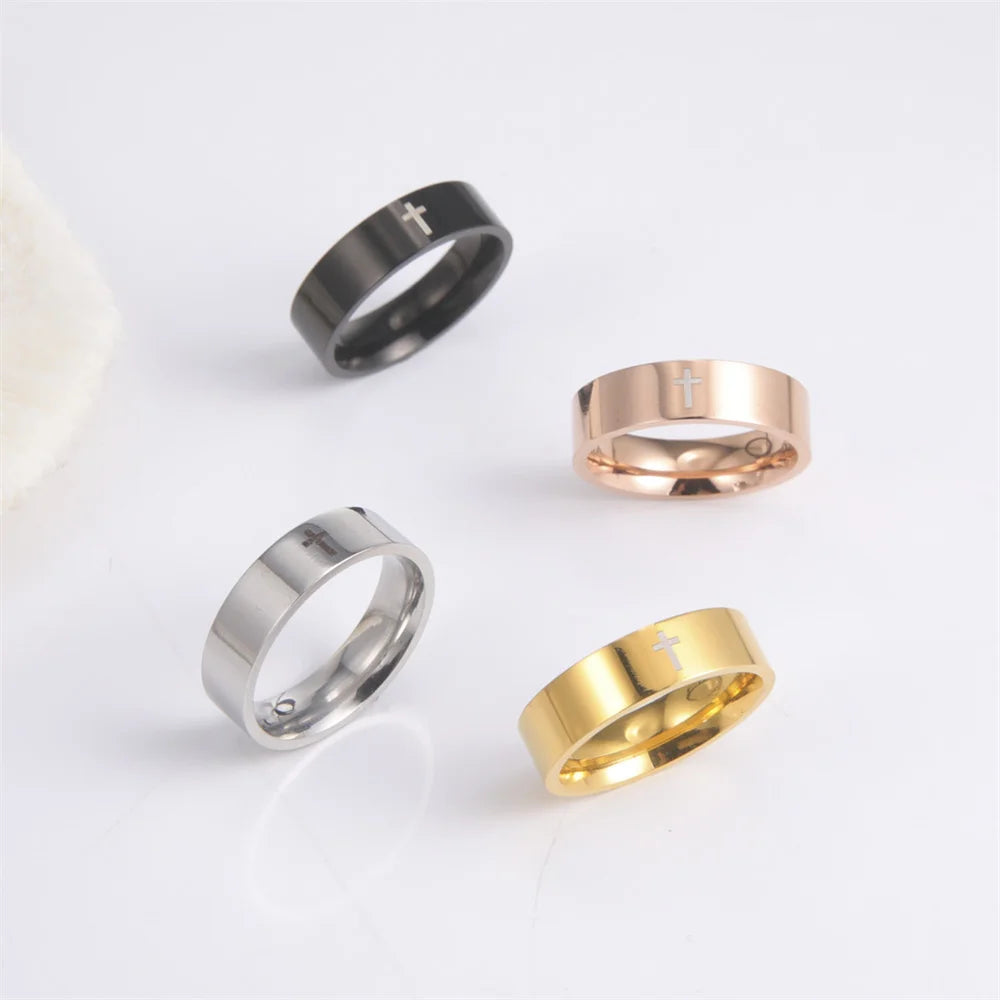 Four rings in black, silver, rose gold, and gold on a light gray background
