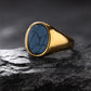 Gold ring with a blue stone on a dark textured surface