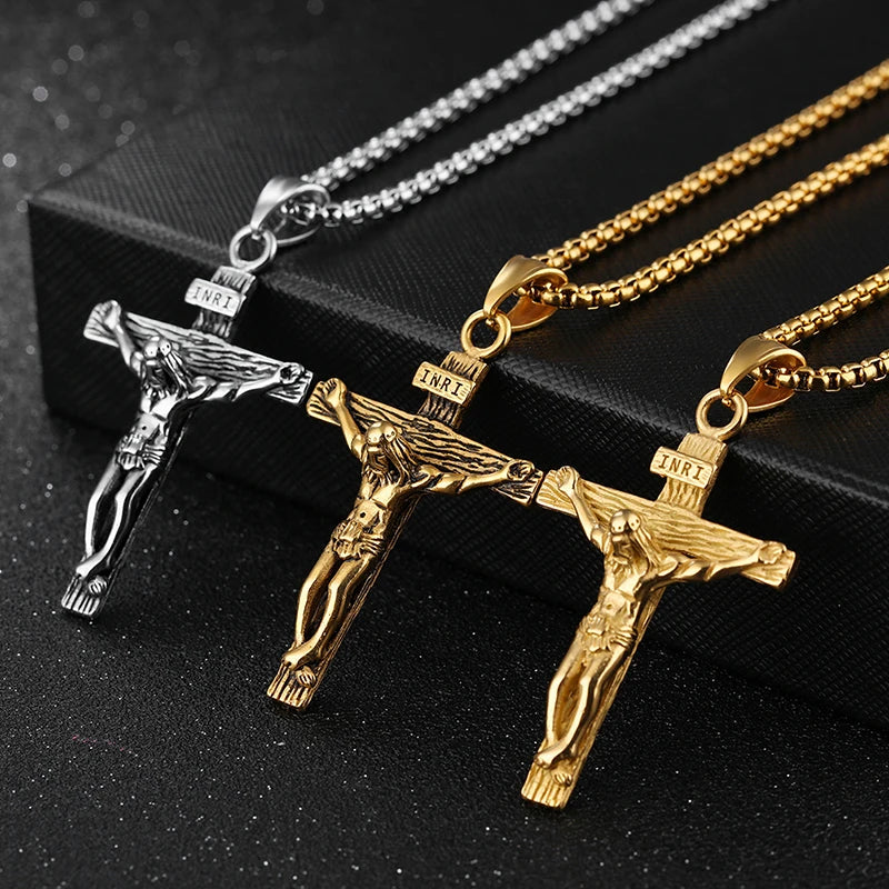 Three crucifix pendants on chains against a black background